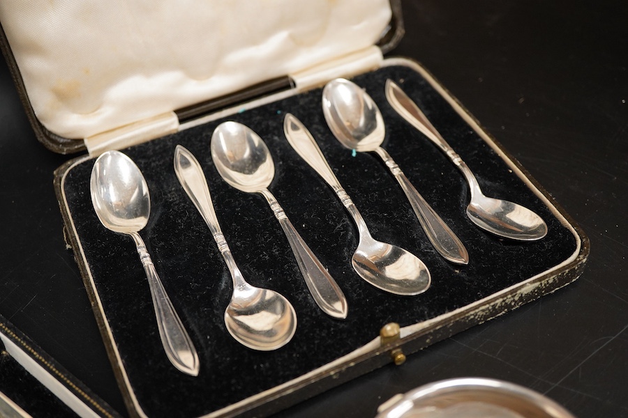 Two cased sets of six mid 20th century silver coffee spoons including Barker Brothers Silver Ltd, Birmingham, 1940, together with a silver and sterling napkin rings and a silver tea strainer on stand.